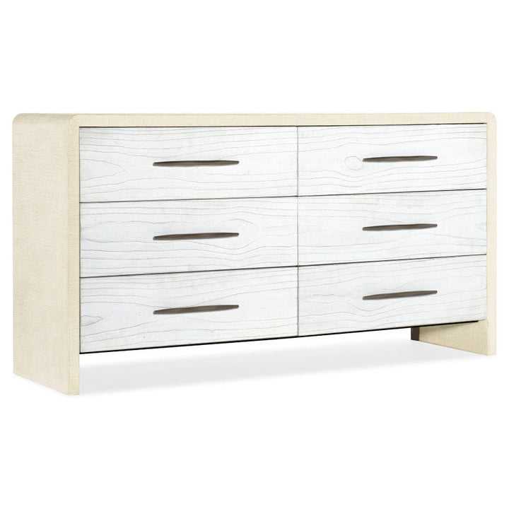 A modern 6-drawer dresser with white-washed wood grain drawer fronts and a light beige textured fabric side panels and legs, shown on a white background.