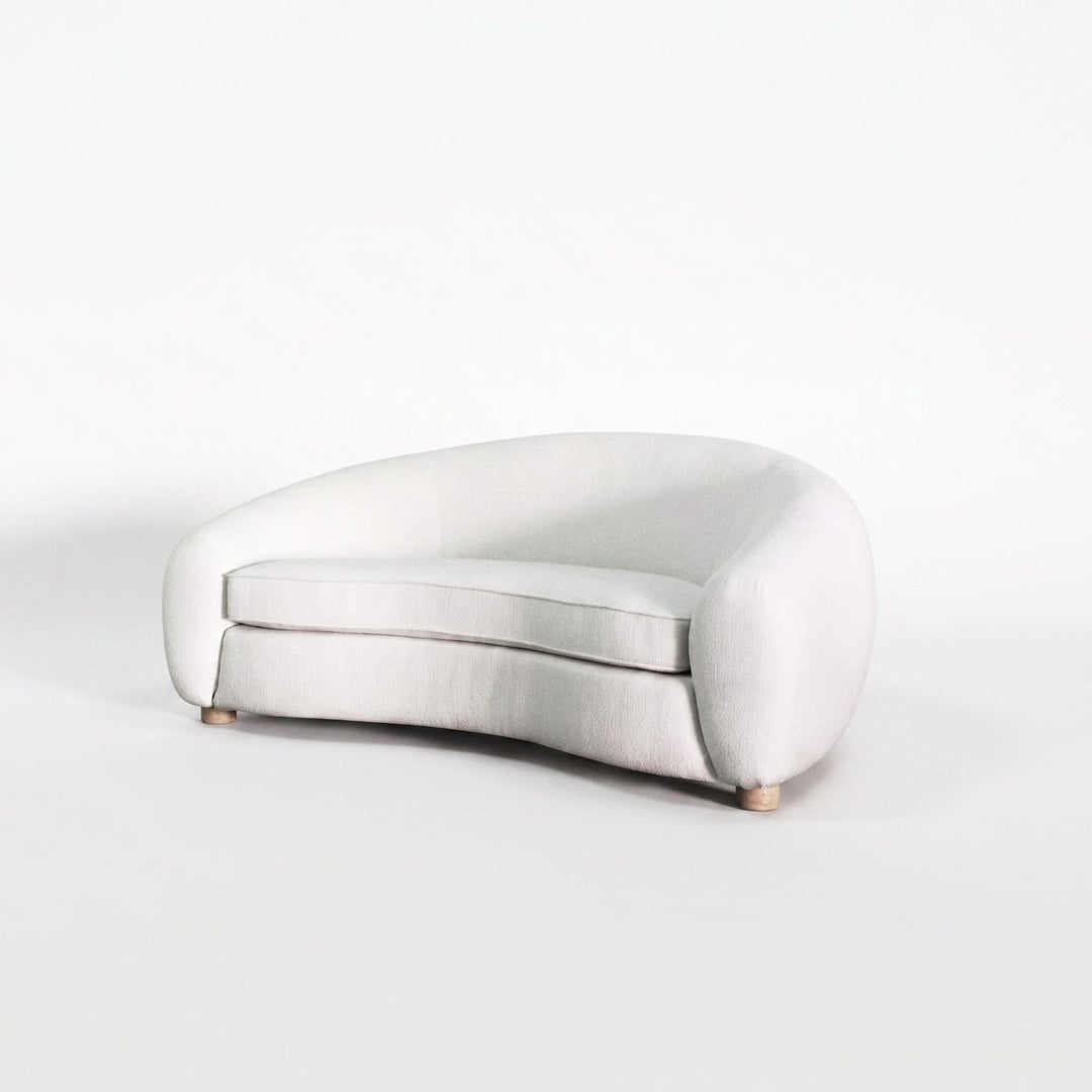 A modern curved lounge chair upholstered in a light off-white fabric, shown on a seamless white studio background.