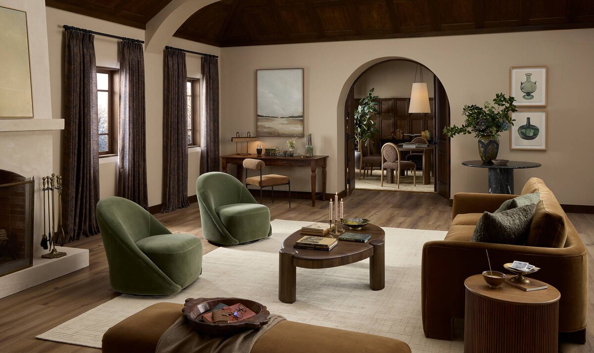 Luxurious living room with green armchairs, brown sofa, and wooden coffee table.