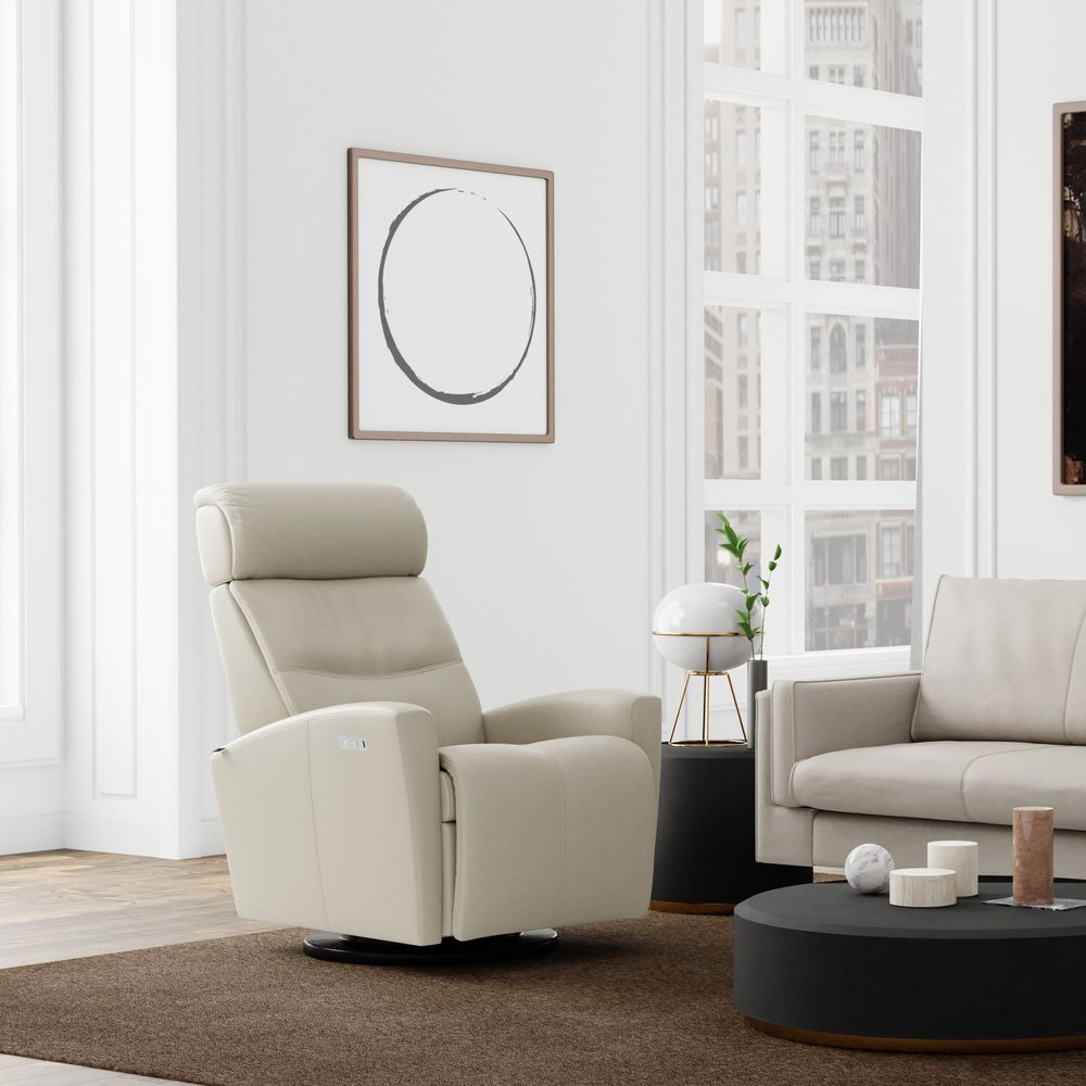 Modern living room with beige sofa and armchair, round coffee table, and abstract art on the wall.