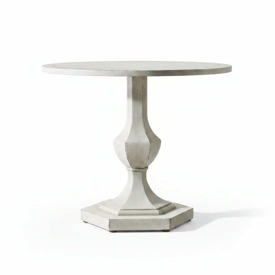 Round decorative table with a pedestal base in a room setting