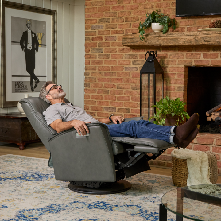 Man relaxing in a recliner chair in a cozy living room with a fireplace.