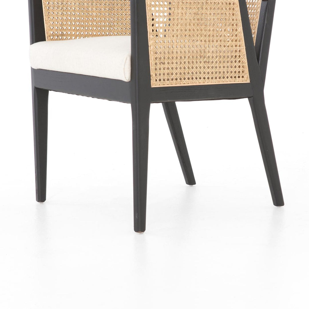 Close-up of the Antonia chair showing natural cane, neutral fabric seat and brushed ebony wood frame