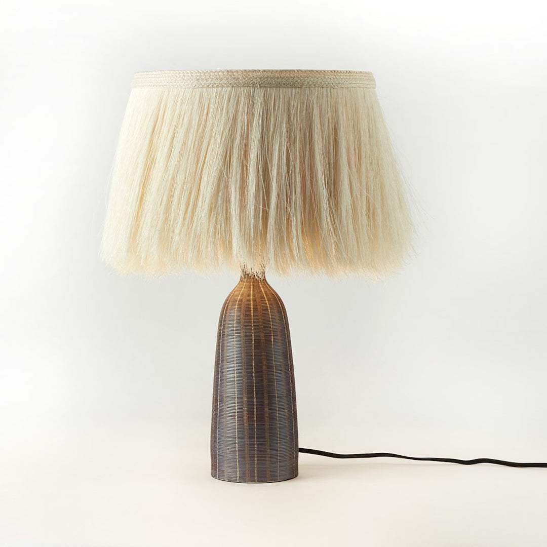 Four Hands Sisa Table Lamp with earthtone striped ceramic base and ivory fringed shade