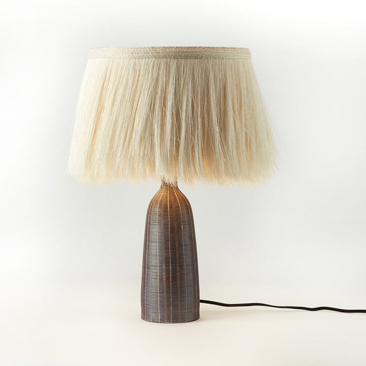 Four Hands Sisa Table Lamp with earthtone striped ceramic base and ivory fringed shade
