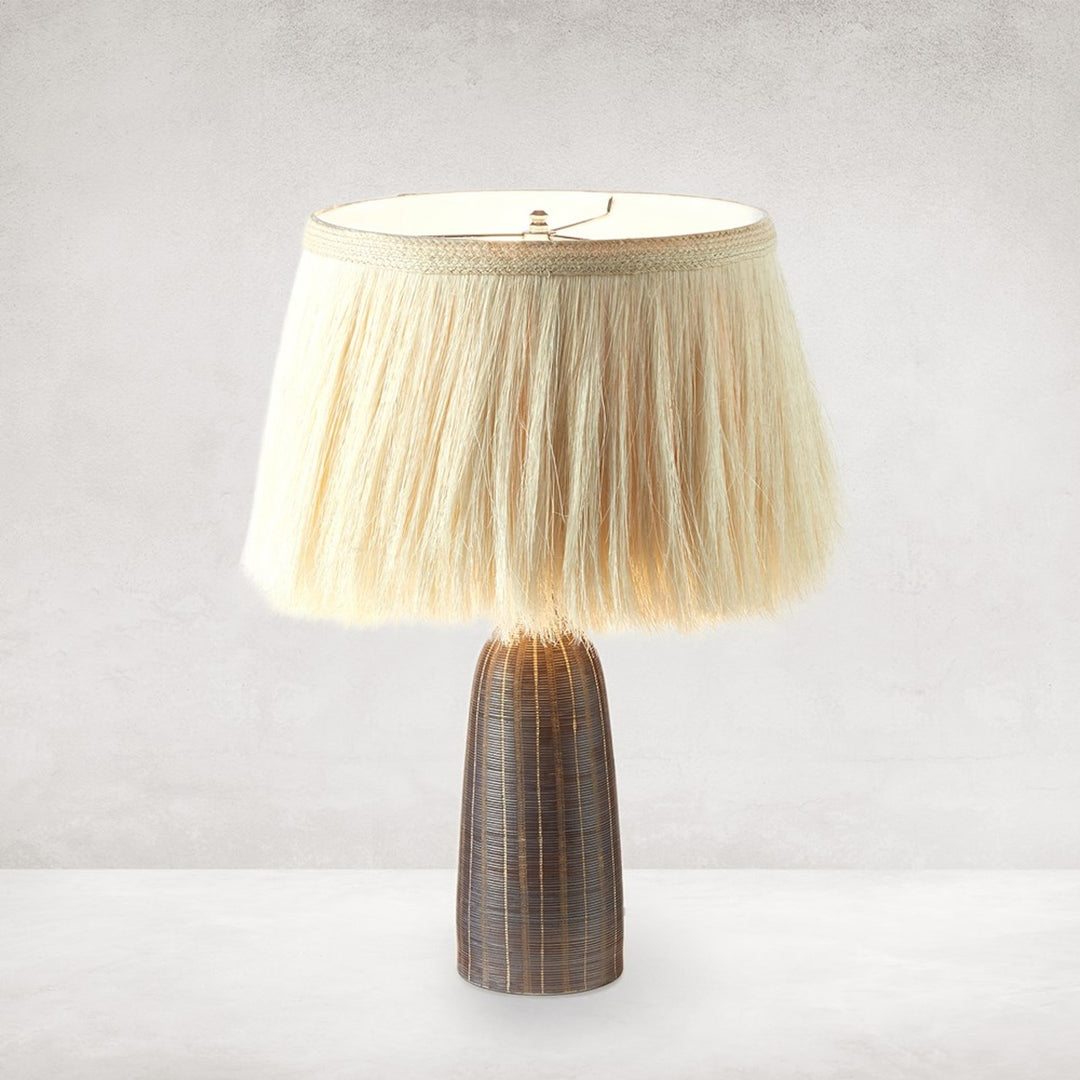 Sisa Table Lamp illuminated, showing the handpainted ceramic base and textured ivory shade