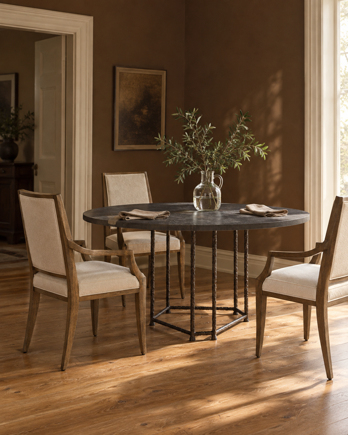 Baker Aitne stone dining table with Jonathan Charles Barcelona chairs in warm natural window light.