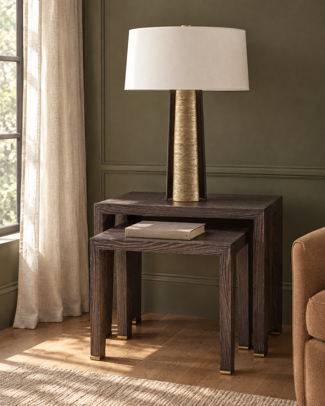 Cloak table lamp on Ponte nesting tables beside a window in an olive-green sitting room.