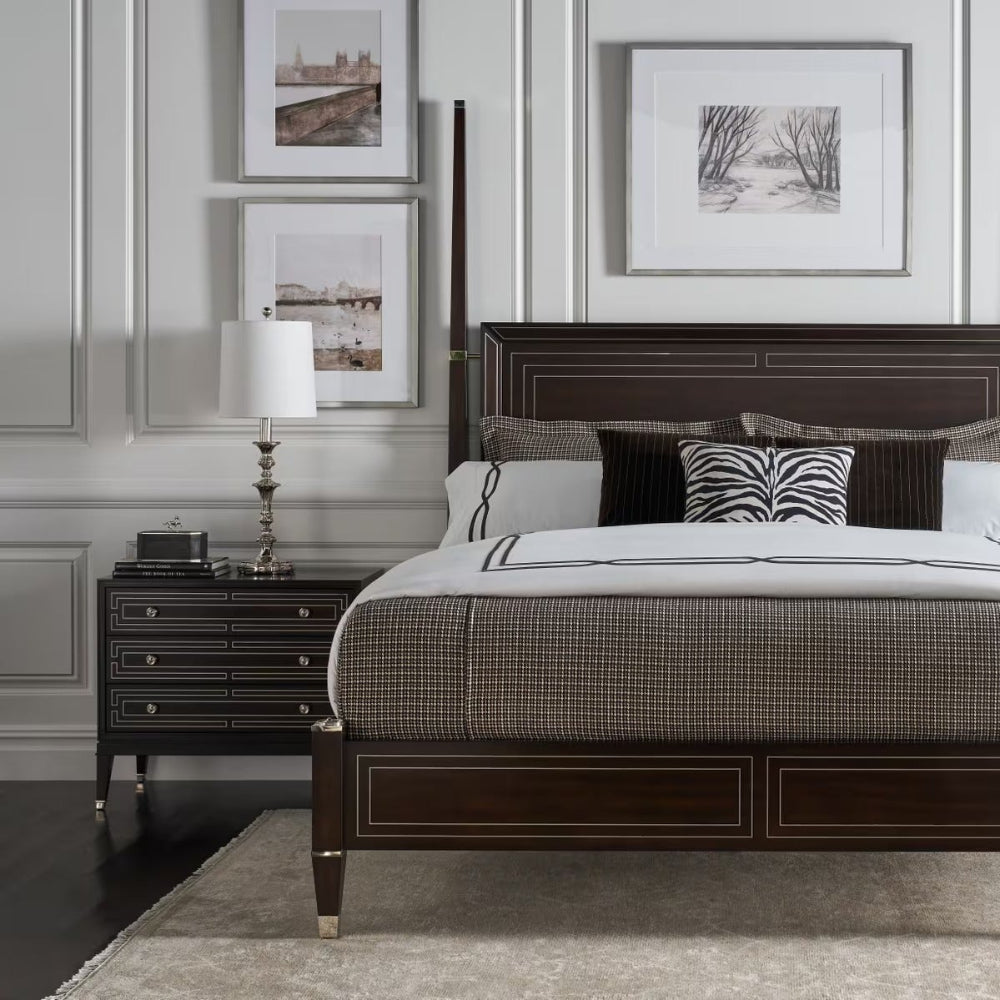 Luxury bedroom with a dark wood bed, nightstands, and framed art on the wall.